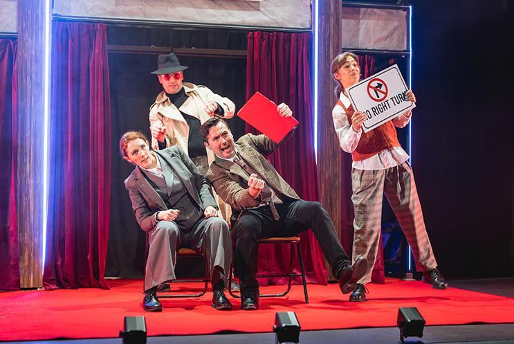 Four performers using chairs like a vehicle