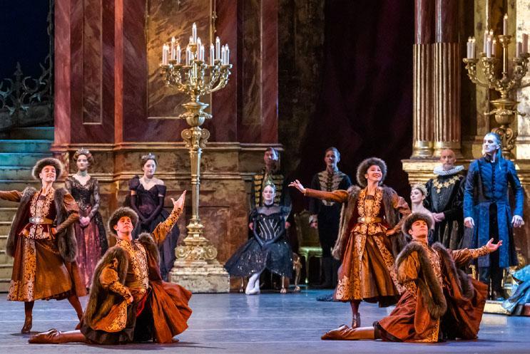 A group dressed in regal attire gesturing with their arms.
