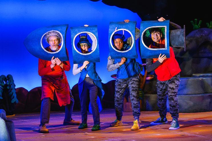 A group of people holding up a cardboard rocket-ship