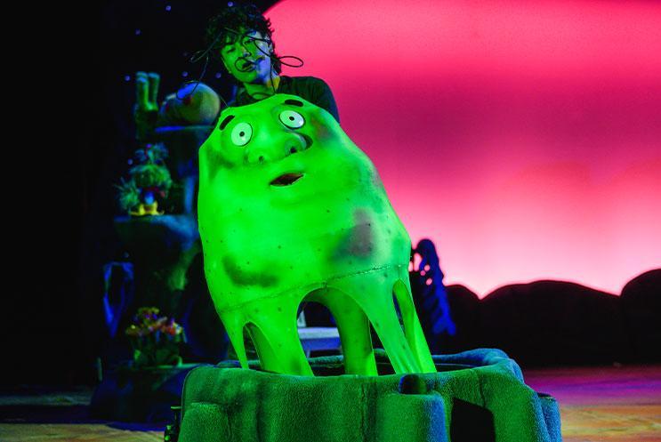 A large glowing puppet of a gooey alien