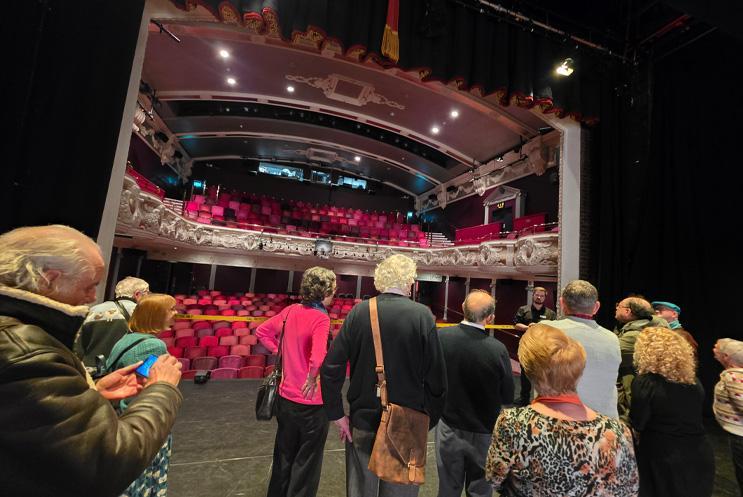A group gathered on the stage looking out into the auditorium