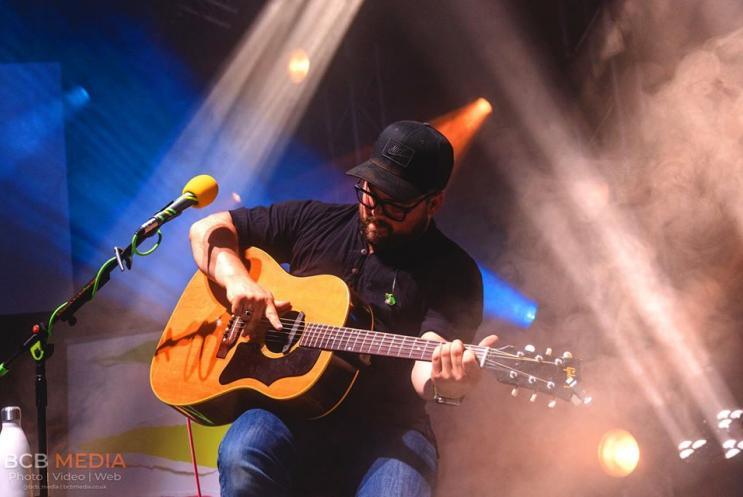 A man playing a guitar on stage