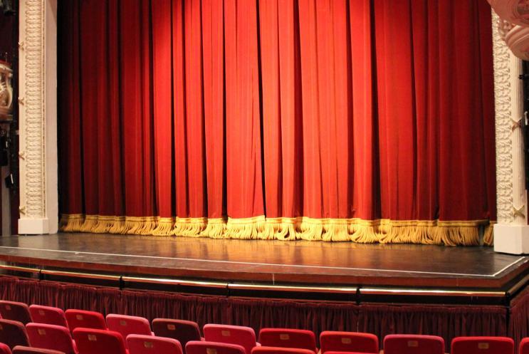 A theatre stage and large red curtain
