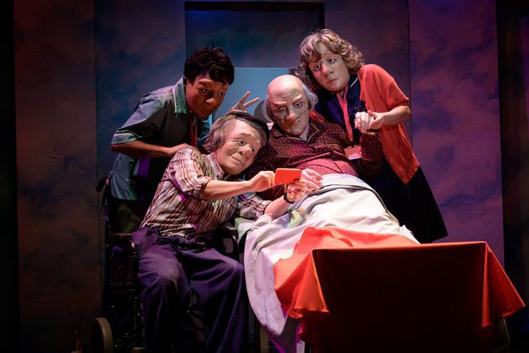 Group of performers in masks gathered around a phone