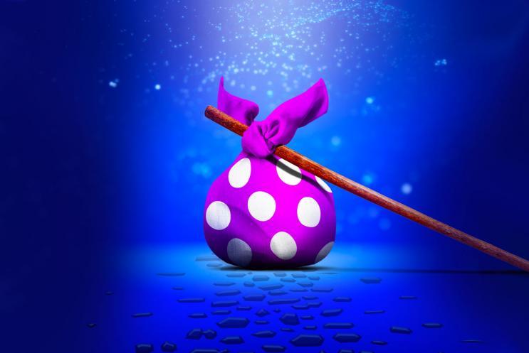 A bindle in the middle of a cobbled street, surrounded by sparkling and magical lighting.