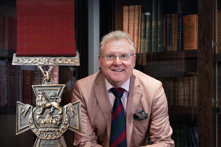 Mark Smith standing in front of a large bookcase