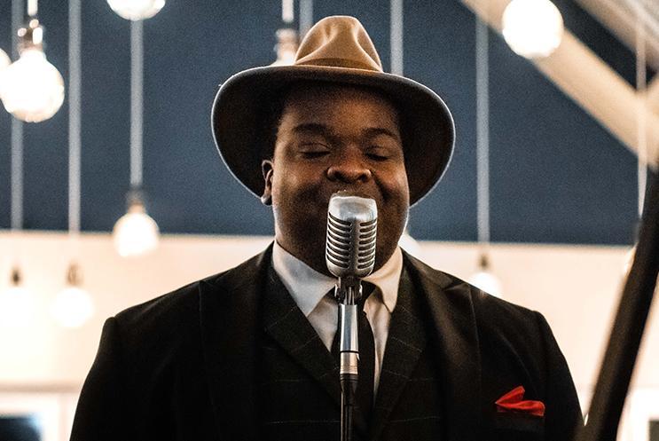 male jazz singer singing into microphone