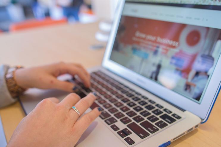 Hands typing on a laptop