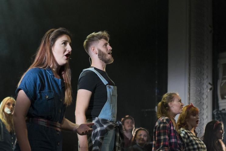 Two student performers singing on a stage