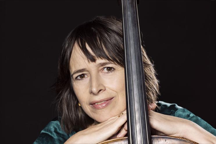 A person leaning against a musical instrument