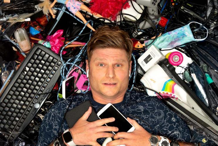 Scott Bennett lying on the ground surround by tech items