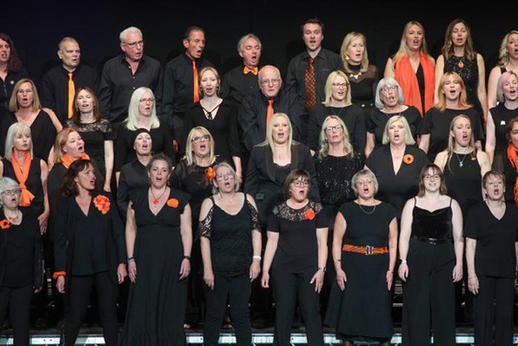 Big group choir all in black and singing